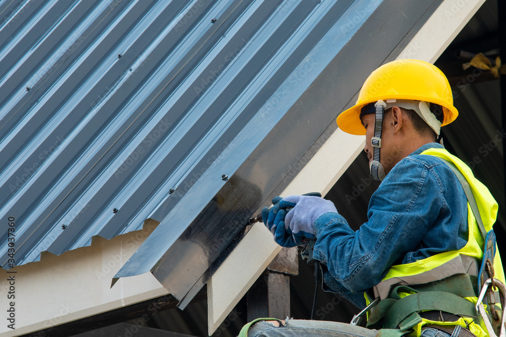 在施工现场从事屋顶结构工作的技术人员，佩戴安全带的施工人员