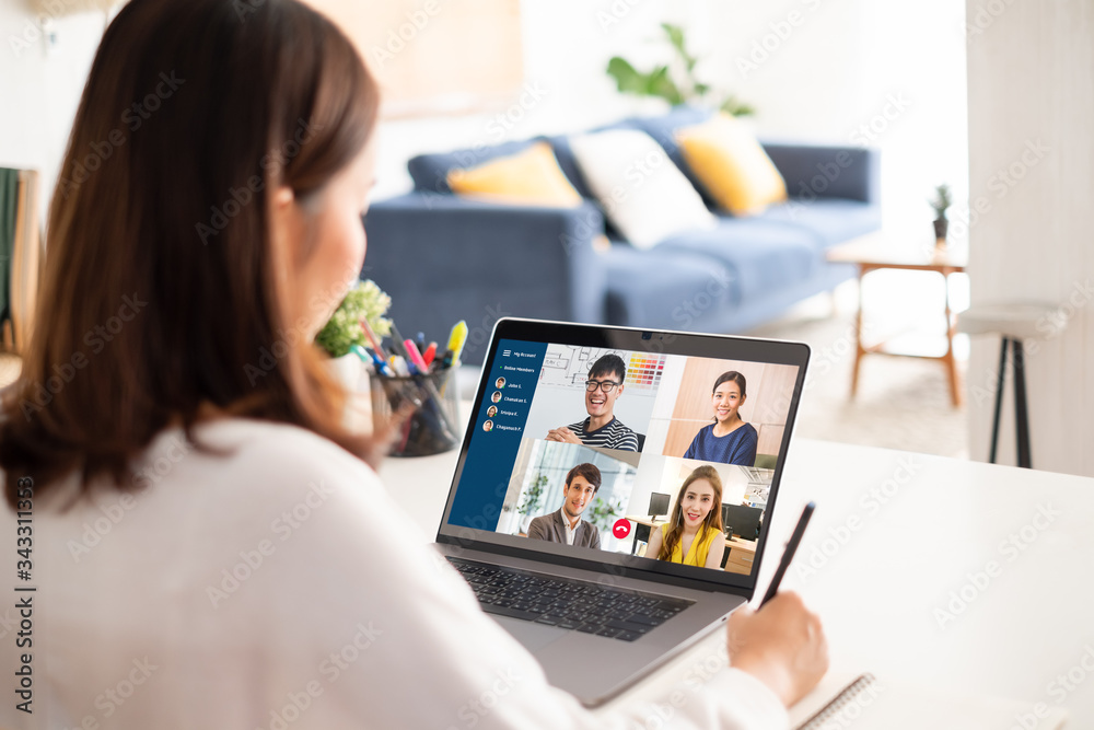年轻的亚洲女商人在家工作，与同事举行虚拟视频会议