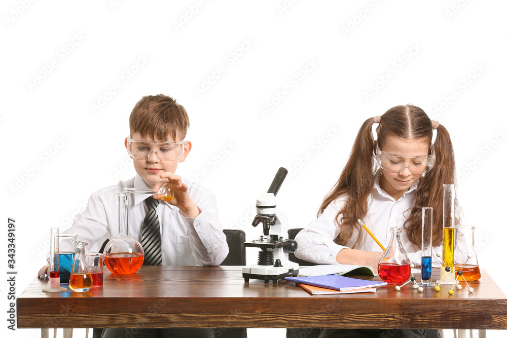 Cute little children studying chemistry at table against white background