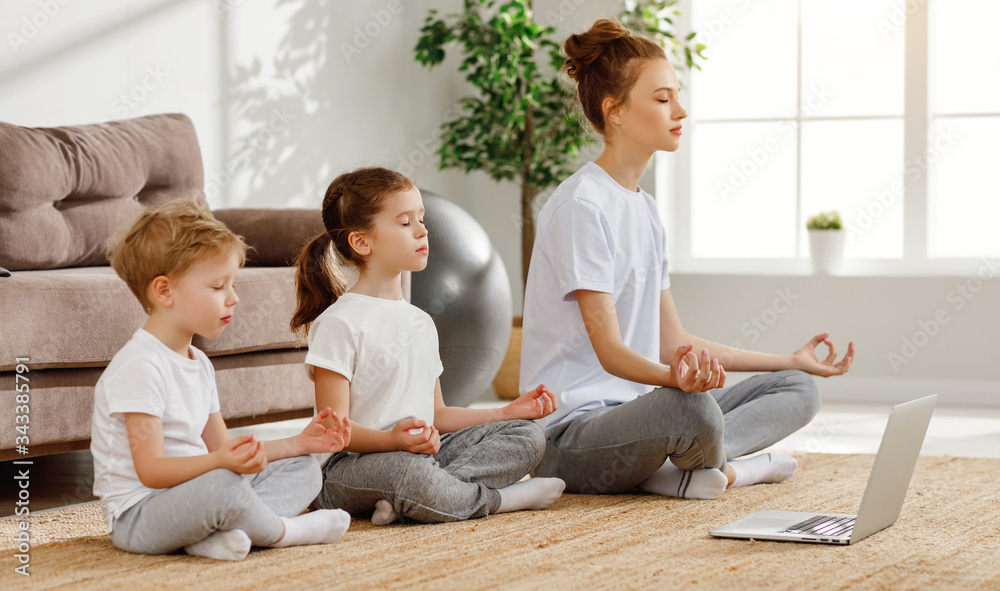 Relaxing mother with children meditating at home.