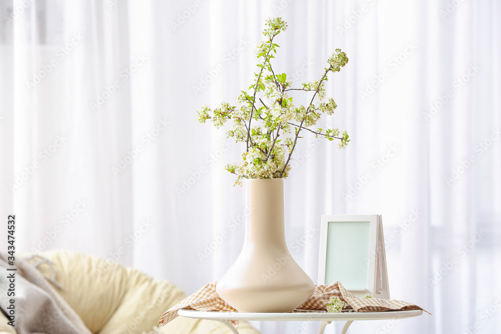 房间桌子上摆放着美丽盛开的树枝的花瓶