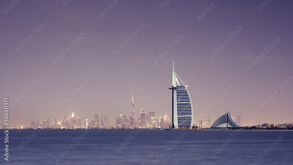 Viewing Dubai cityscape across the sea after sunset. Dubai, United Arab Emirates.