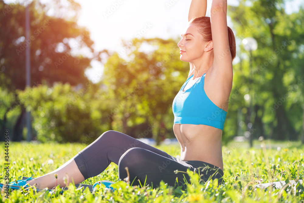Smiling woman training outdoor at sunny day