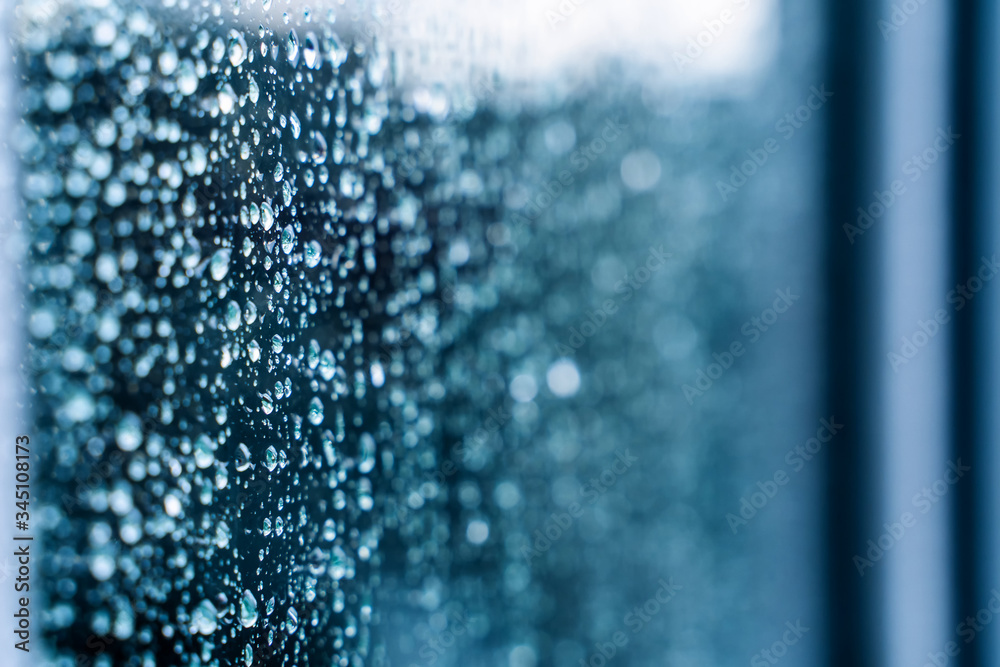 玻璃上的自然水滴。选择性聚焦。雨天城市背景