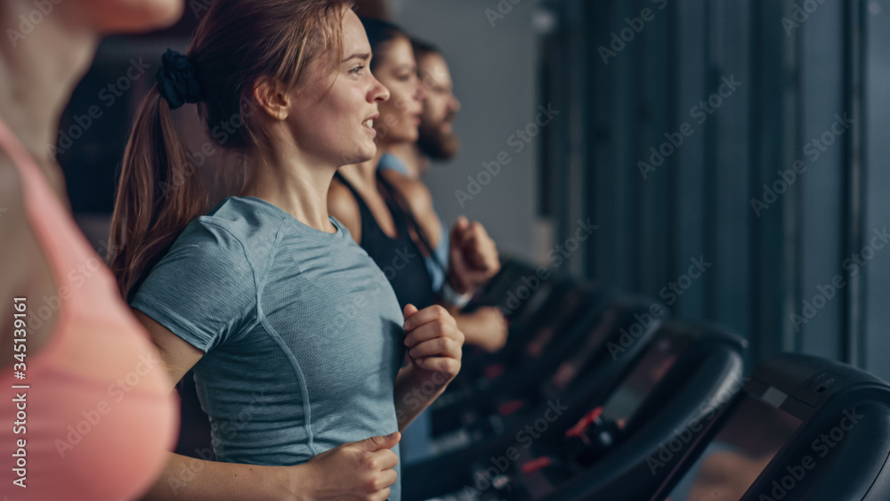 Beautiful Athletic Sports Woman Running on a Treadmill. Energetic Fit Female Athlete Training in the