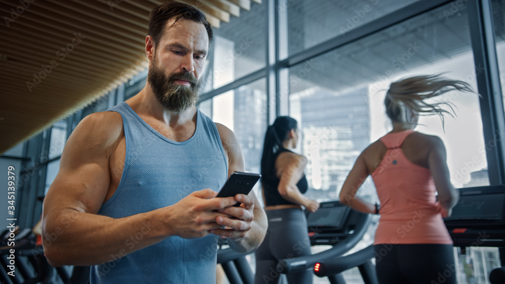 Muscular Heavyweight Champion Walks Through Gym, Uses Smartphone for Social Media and Conducting Bus