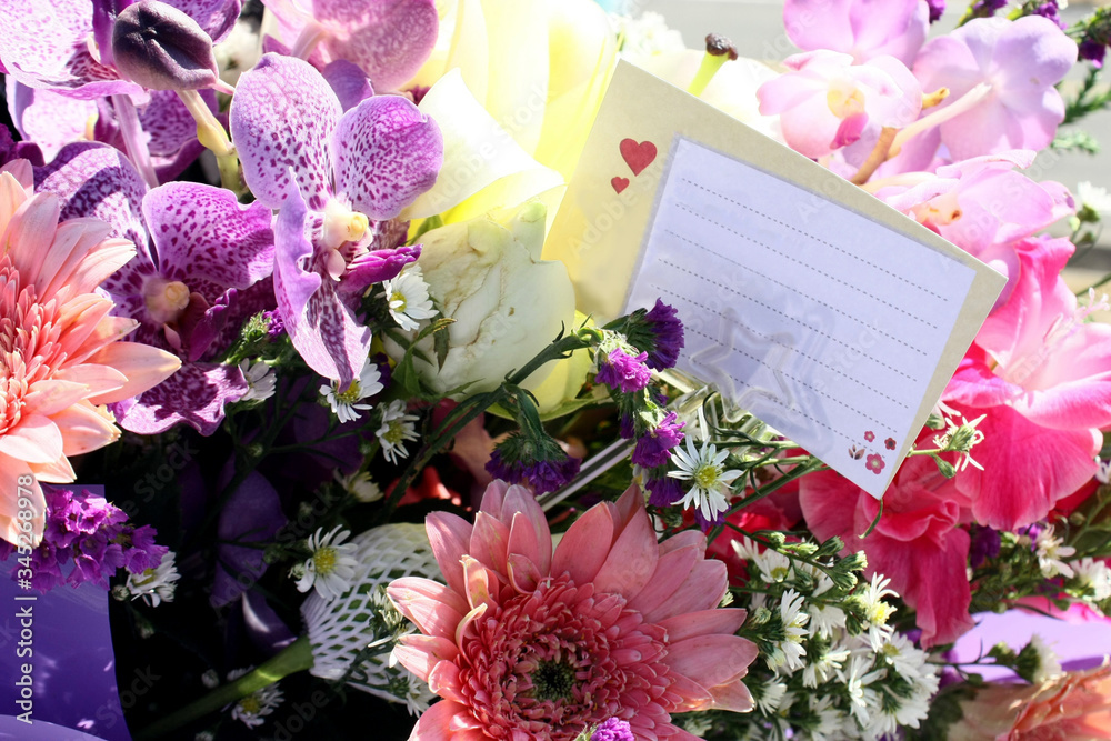A bouquet of flowers to celebrate and the blank card for congratulation