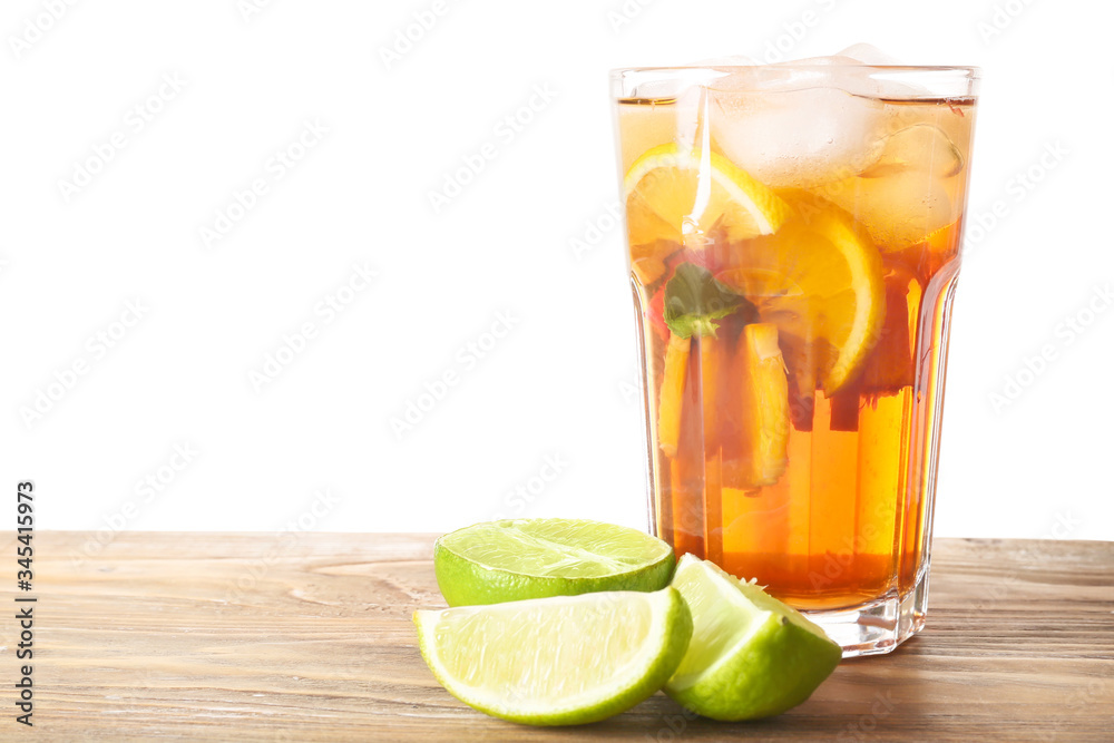 Glass of tasty cold ice tea on table against white background