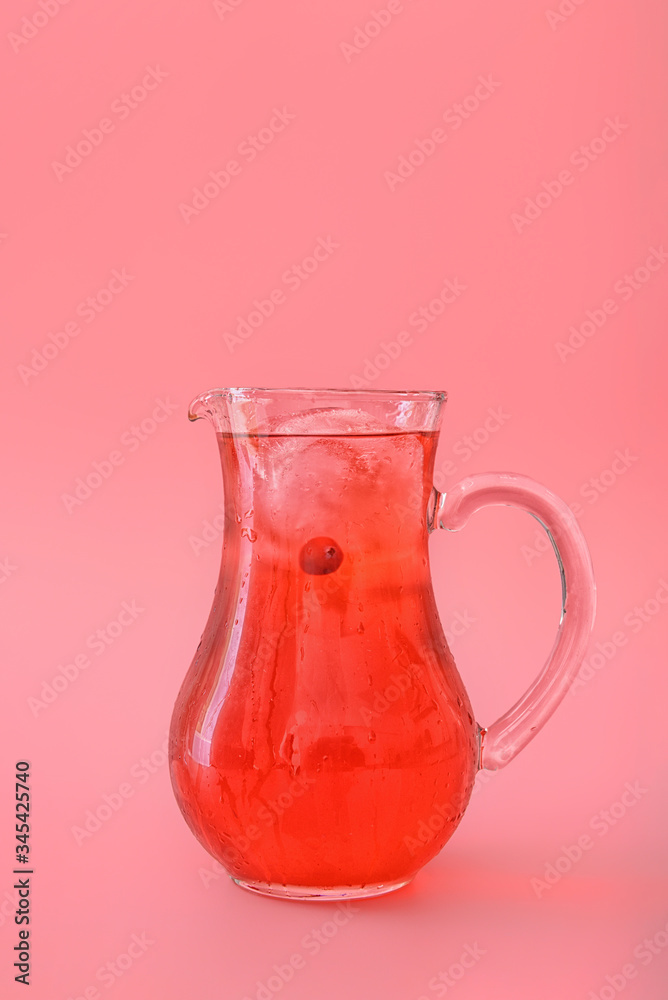Jug of tasty cold ice tea on color background
