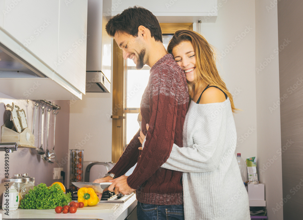 恋爱中的浪漫情侣在家一起烹饪蔬菜健康食品。人和食物的概念