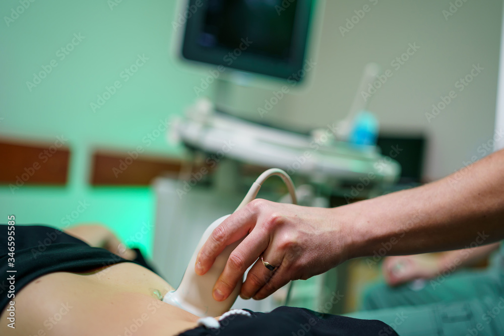Doctor makes the patient women abdominal ultrasound. Ultrasound scanner in doctor`s hands. Diagnosti
