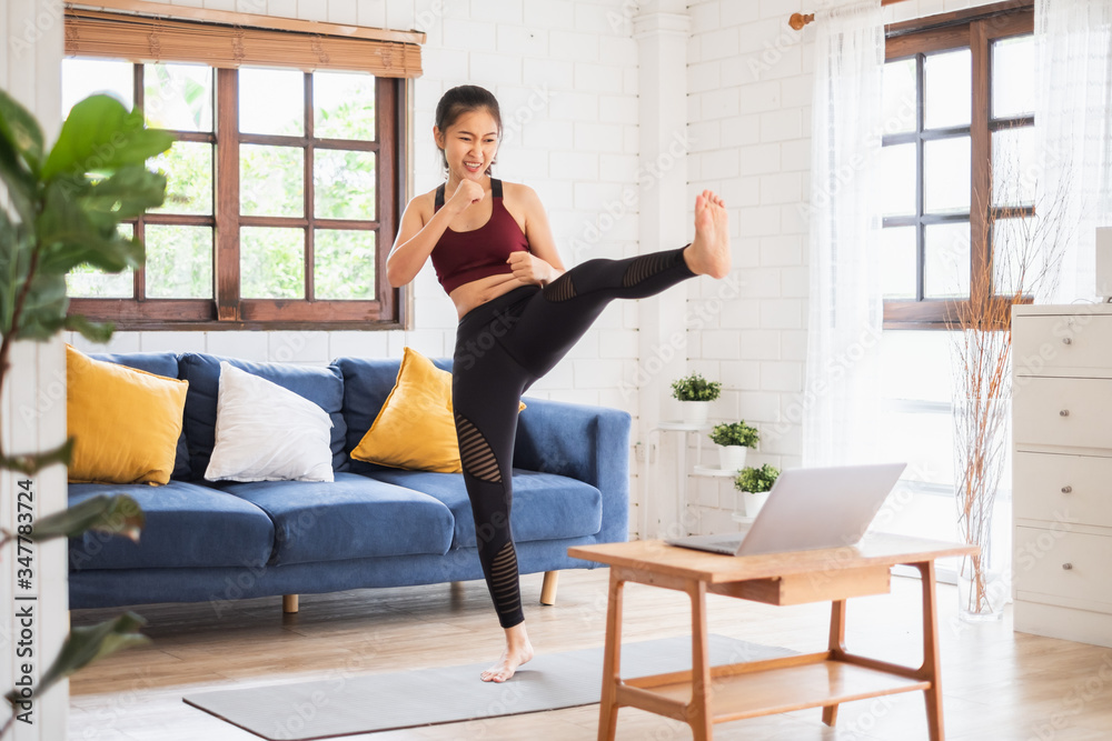 年轻的亚洲健康女性在家锻炼，锻炼，健身，做瑜伽，家庭健身概念