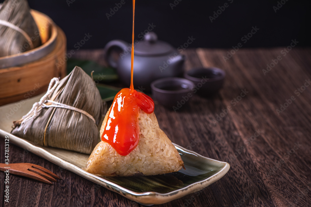 Zongzi - Chinese rice dumpling zongzi in a steamer on wooden table black retro background for Dragon