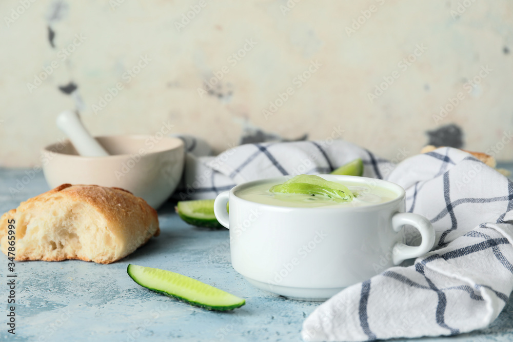 Pot with cold cucumber soup on table