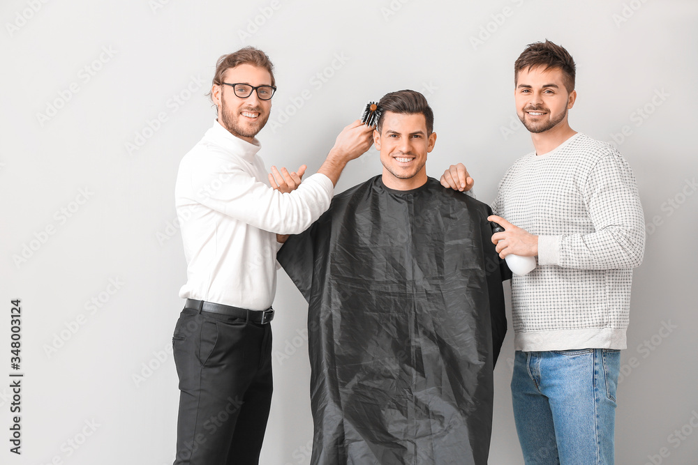 年轻理发师在白色背景下与客户合作