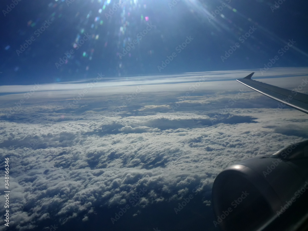 在飞行中透过飞机的窗户看。云层和美丽的蓝天。