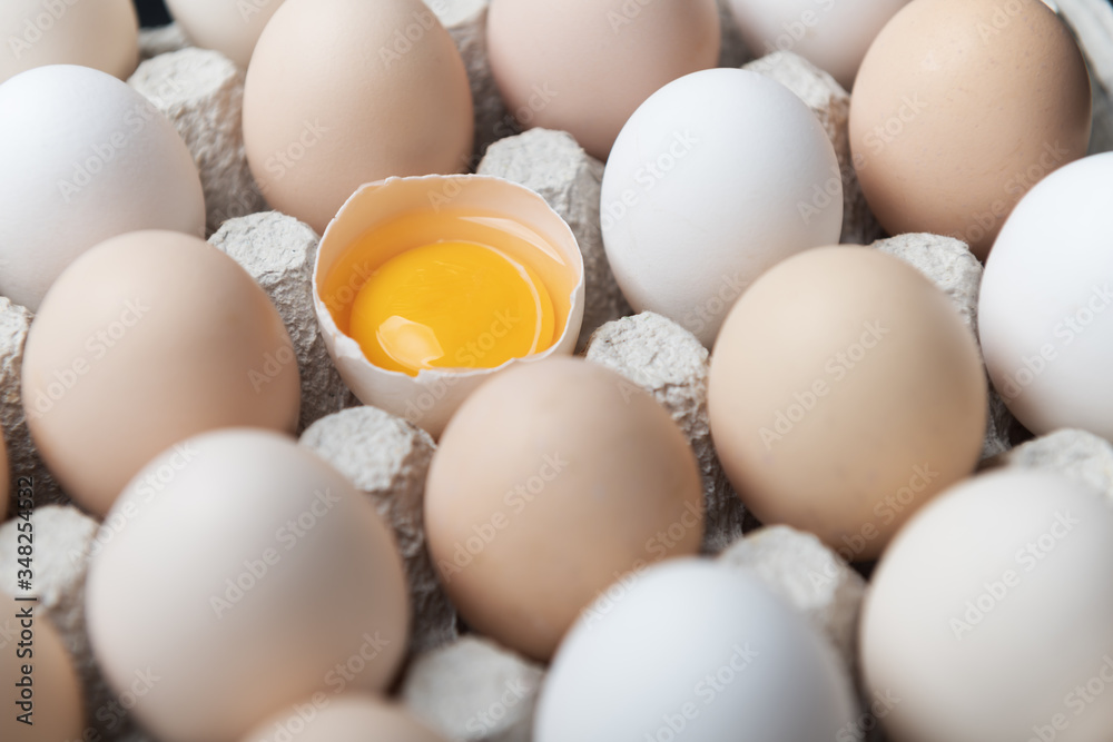 有机包装的鸡蛋特写。鸡蛋在其他鸡蛋中被打碎了一半。食品摄影