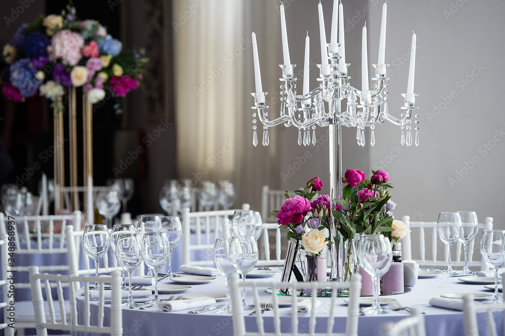in the white hall of the restaurant there are tables with festive decor for a wedding celebration, d