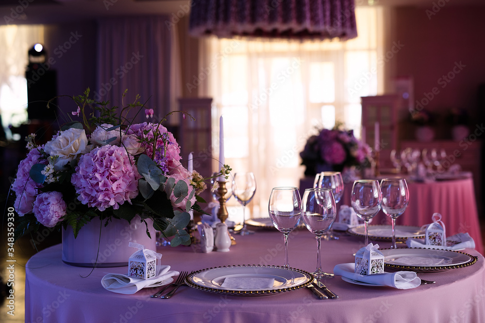 粉红色餐厅的餐桌，节日晚餐，账单上有一束粉红色的花