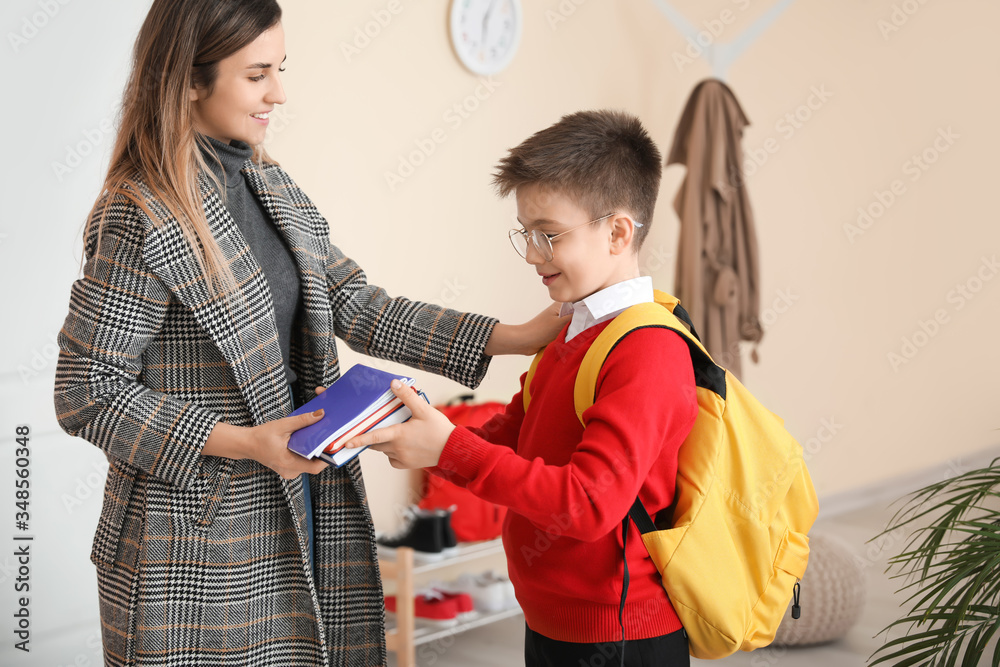 Mother giving books to her son before school