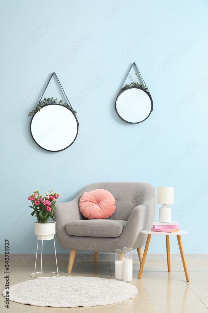 Interior of living room with stylish mirrors and armchair