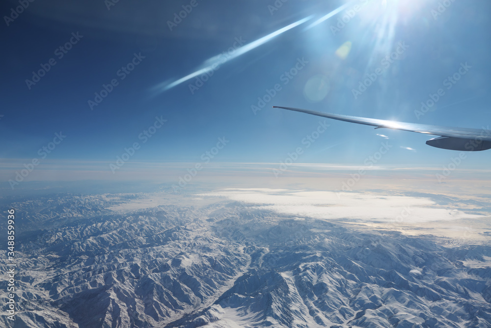 在罕见的白云下，从飞机上看到广阔的蓝天，这是一片无边无际的神奇山脉