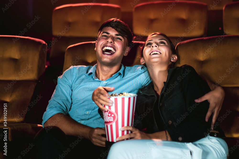 男男女女在电影院看电影。集体娱乐活动和娱乐男性