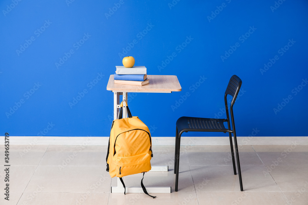 Modern school desk near color wall