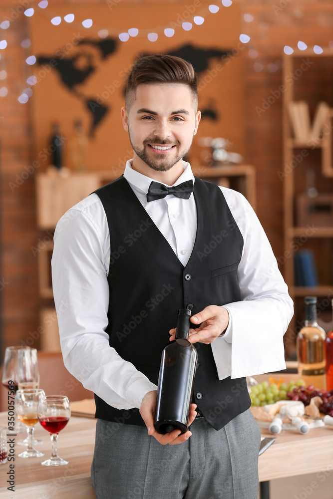 餐厅服务员拿着一瓶葡萄酒