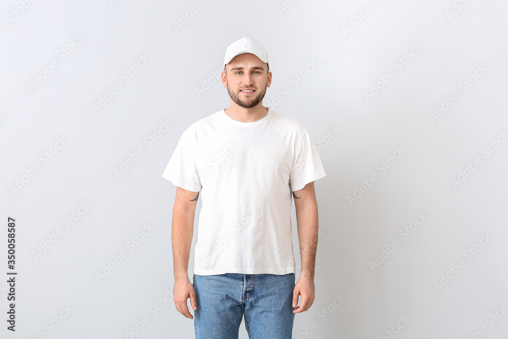 Handsome man in stylish cap on light background