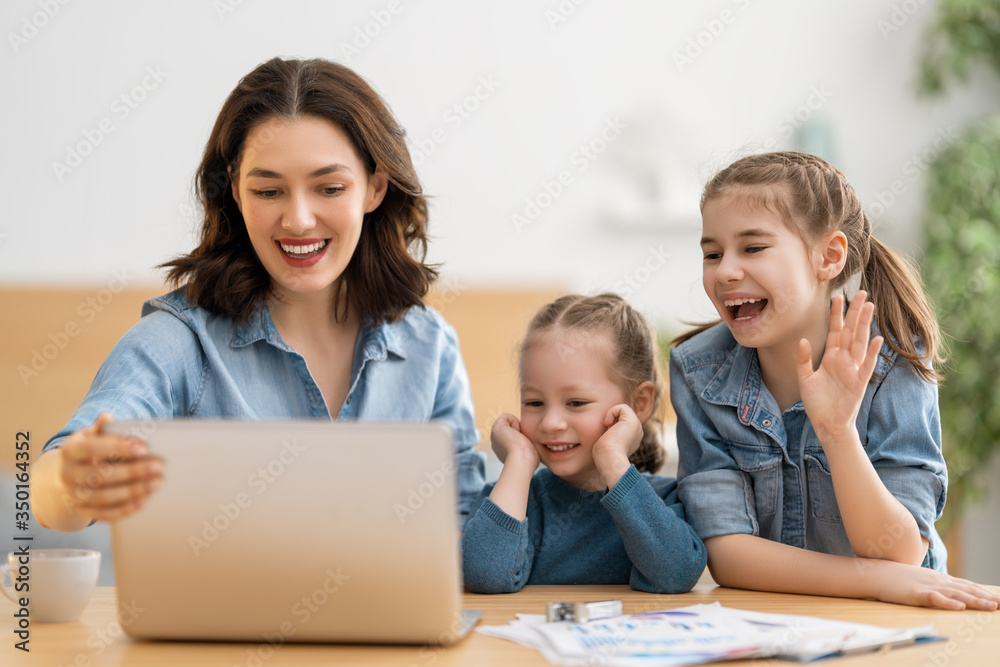 带着孩子在电脑上工作的母亲