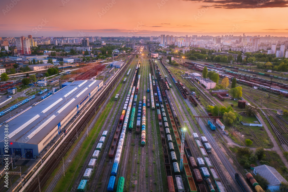 日落时货运列车的鸟瞰图。火车站、货车、铁路的俯视图。重型工业