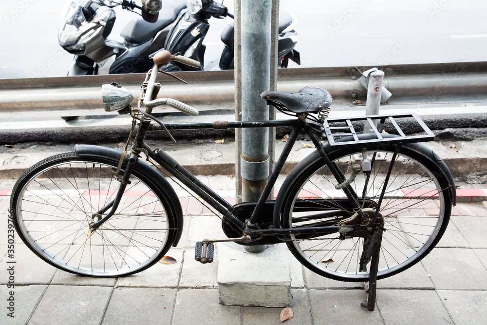 黑色古董自行车停在电线杆旁的脚浴上