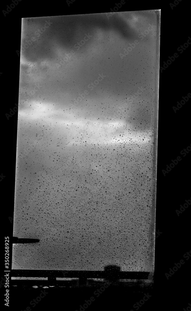 台风。台风期间一个大而垂直的窗户的黑白照片。
