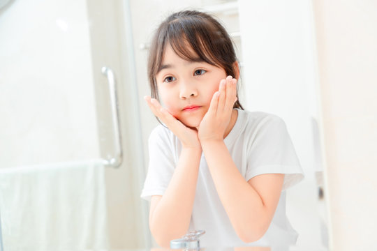 Asian little girl washing her face