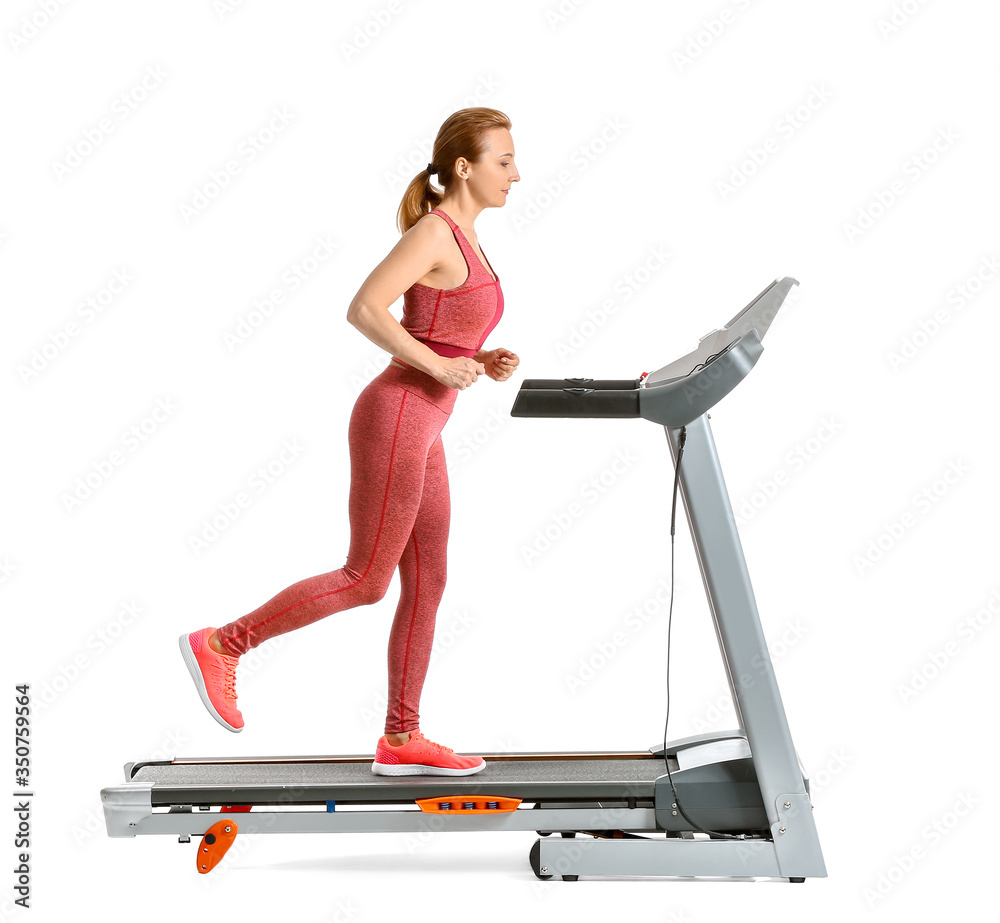 运动型女性在白色背景下的跑步机上训练