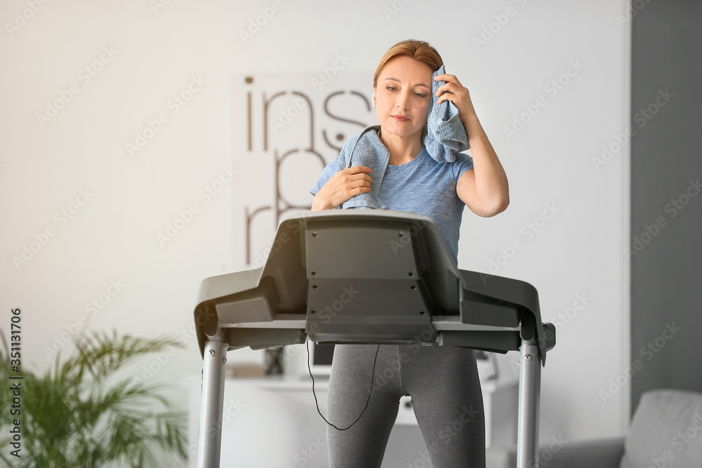 运动型女性在家跑步机上训练后休息