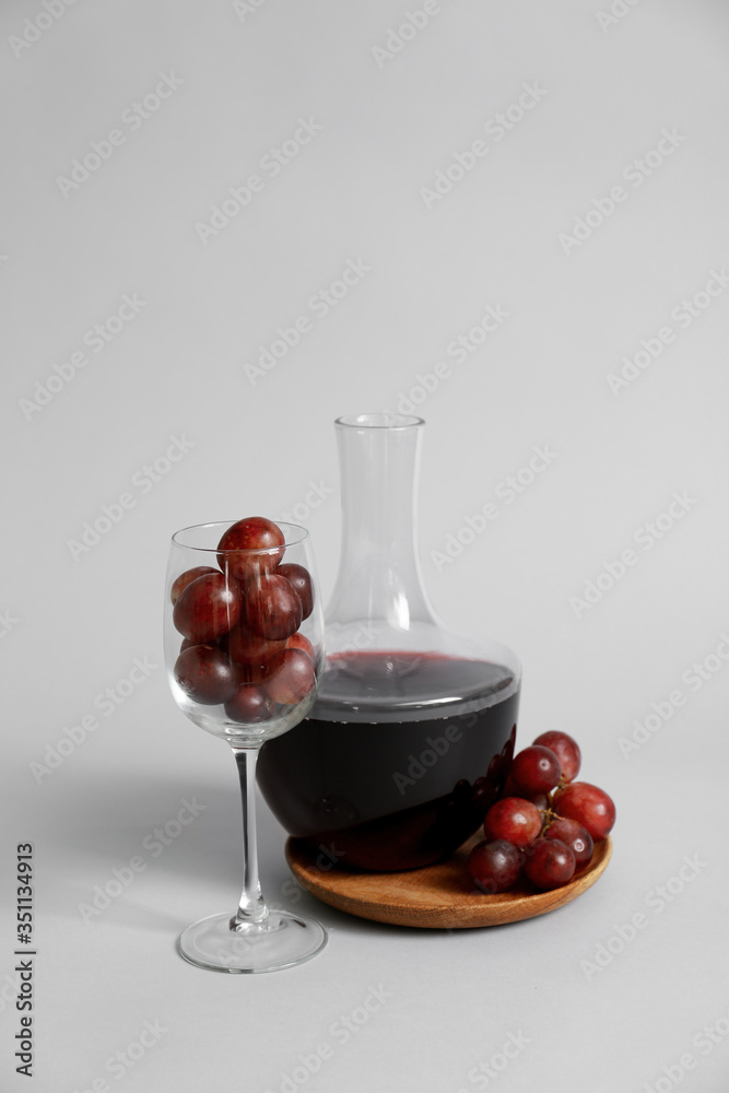 灰色背景下的葡萄酒与葡萄和玻璃杯