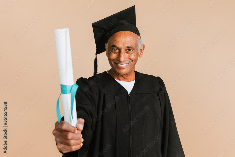骄傲的大四学生，穿着毕业礼服，手里拿着毕业证书