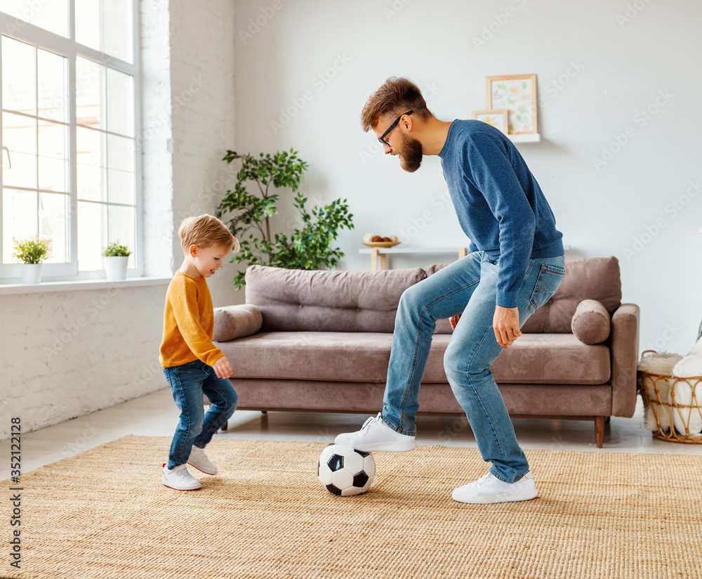父子俩在舒适的房间里踢足球。