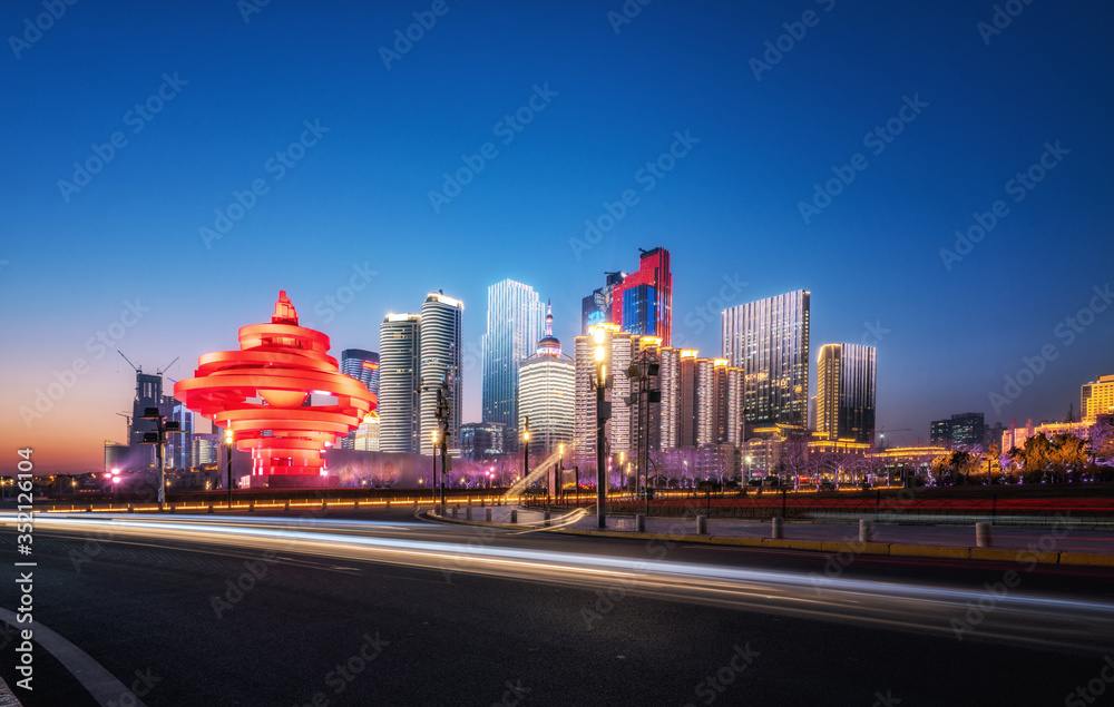 Road and night view of Qingdao urban architecture..