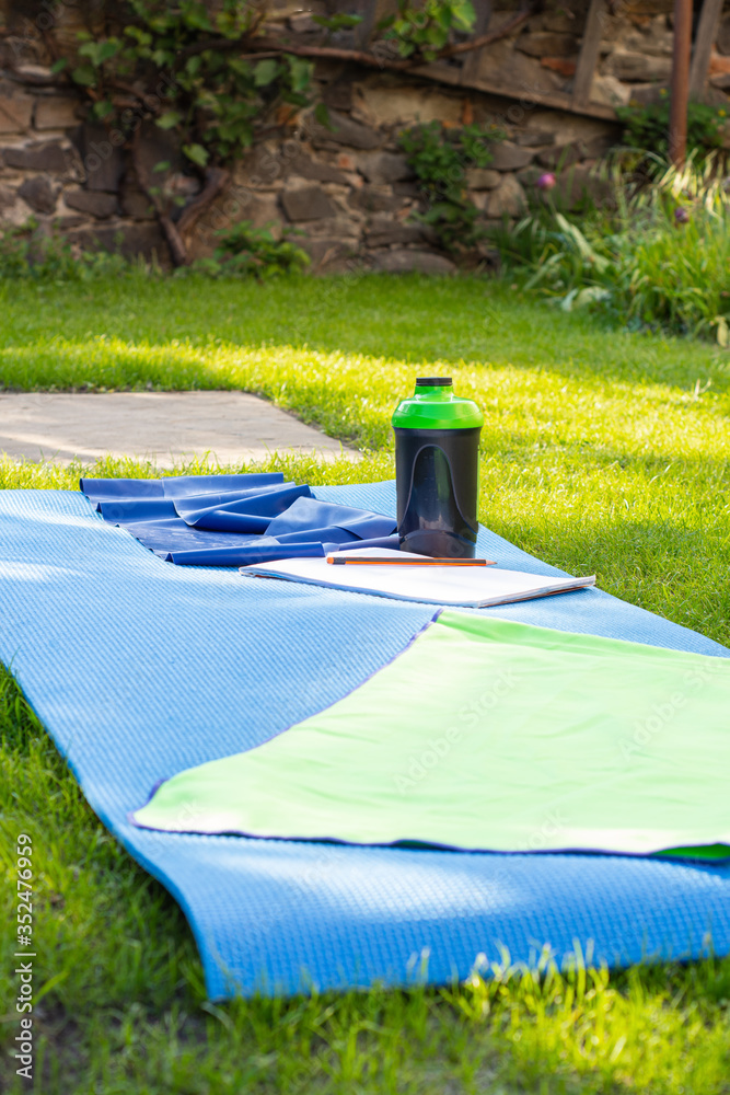  Karemat, towel,  sports bottle  and rubber tape outdoors