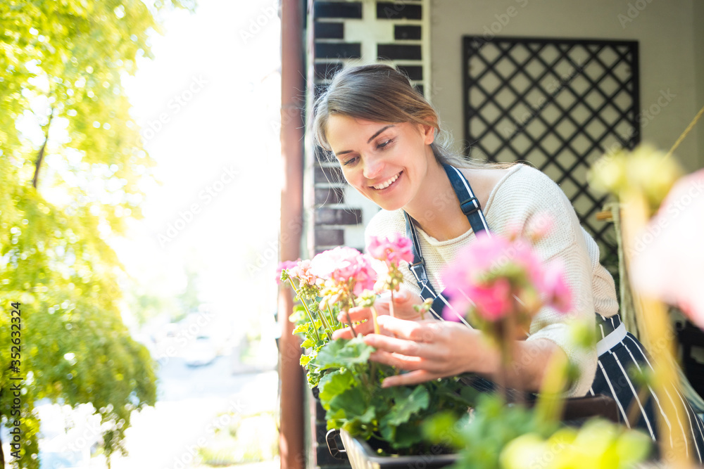 女人在阳台上打理花朵，在家园艺