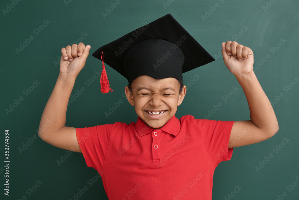 快乐的非裔美国男孩，戴着彩色背景的毕业帽