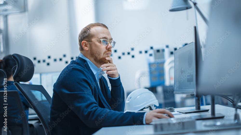 男工业工程师解决问题，在个人电脑上工作的照片，他正在工作
