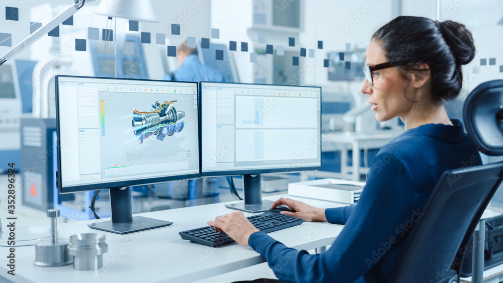 工业女工程师在个人电脑上工作，两个监视器屏幕显示CAD软件智慧
