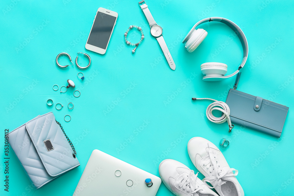 Frame made of female accessories, laptop, headphones and mobile phone on color background
