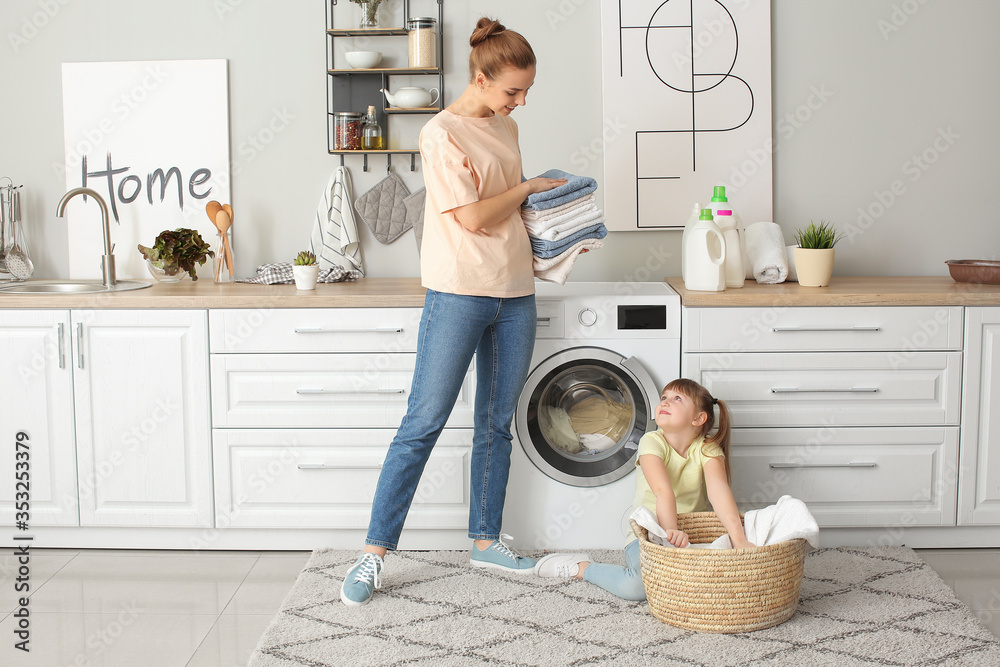 女人和她可爱的小女儿在家洗衣服