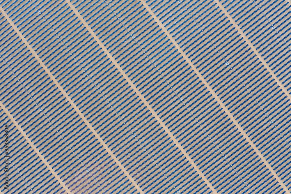 Aerial view of a photovoltaic solar panel farm producing sustainable renewable energy in a desert po