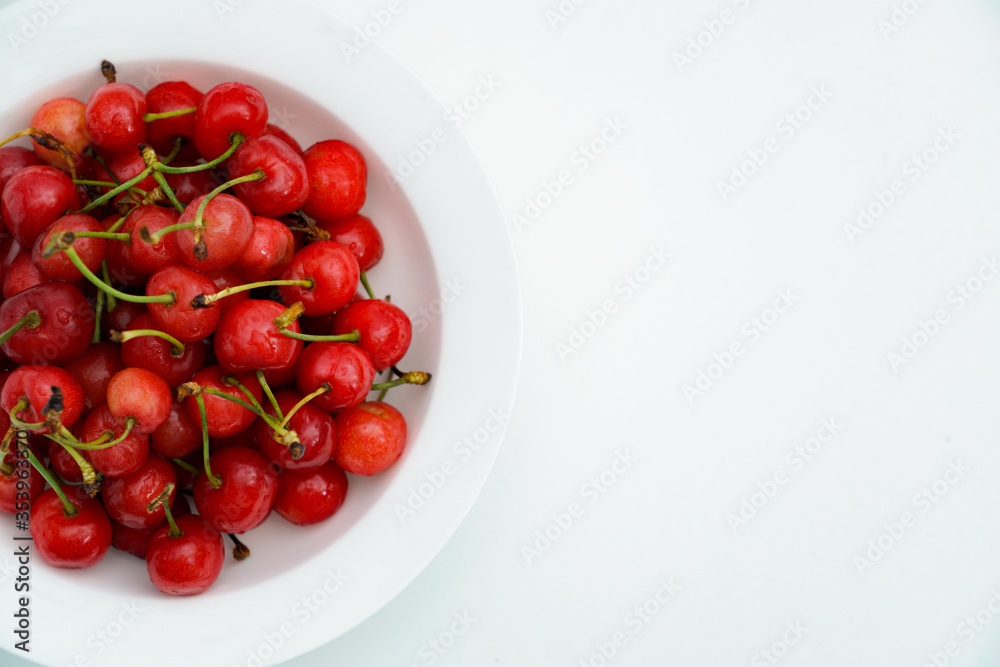 Fresh cherries in a white porcelain dish.